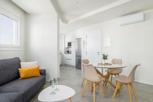 a living room with a couch and a table and chairs at Apartamento Vidamar 1 in Conil de la Frontera