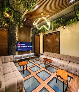 a living room with couches and a flat screen tv at The White Suites in Karachi