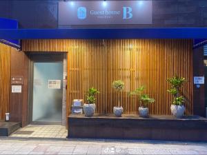 a front of a building with potted plants on it at guest house B in Osaka