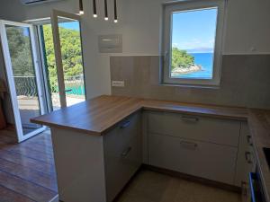 a kitchen with a counter with a view of the ocean at Apartment Jagoda in Postira