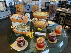 a display of desserts and jams on a glass table at Luna Hotel dos Carqueijais - Serra da Estrela in Covilhã