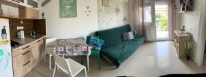 a living room with a green couch and a table at Golden-Beach Apartman in Siófok