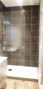 a bathroom with a shower with gray tiles at maison ville st aff in Saint-Affrique
