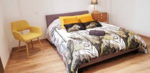 a bedroom with a bed and a yellow chair at maison ville st aff in Saint-Affrique