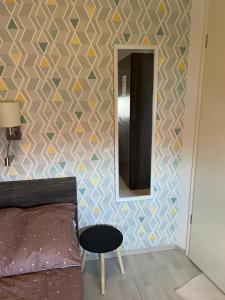 a bedroom with a wall with a mirror and a chair at Golden-Beach Apartman in Siófok