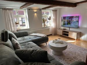 a living room with a couch and a tv at RitterLiving Ferienapartment am Markt in Tangermünde