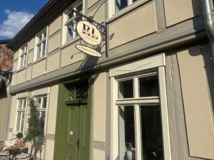a building with a green door and a sign on it at RitterLiving Ferienapartment am Markt in Tangermünde