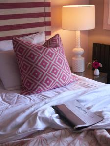a book laying on top of a bed with pillows at Harbour Hotel & Spa St Ives in St Ives