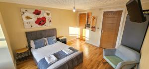 una camera da letto con un letto, un divano e una sedia di Bridge St 6 Bedroom House - Tranent a Tranent