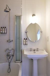 a white bathroom with a sink and a mirror at Harbour Hotel & Spa St Ives in St Ives