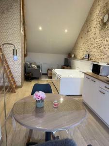 a living room with a table and a kitchen at La Suite Etoilée - Balnéo privative in Courgains +20 photos