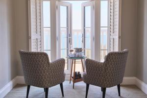two chairs and a table in a room with windows at Harbour Hotel & Spa St Ives in St Ives