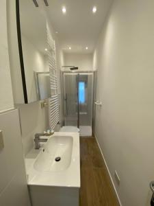a white bathroom with a sink and a shower at Casa Vacanza Alle Pratoline in Muggia +19 photos