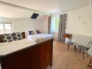 a bedroom with a bed and a table and a window at Villa Oscar in Les Mesnuls