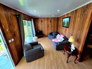 a living room with two couches and a table at Encanto das Caldeiras in Furnas