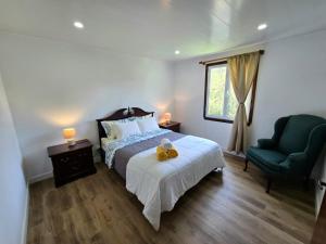 a bedroom with a bed with a teddy bear on it at Encanto das Caldeiras in Furnas