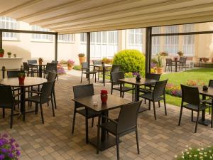 a patio with tables and chairs in a courtyard at Hotel Du Parc - Mulhouse Centre in Mulhouse