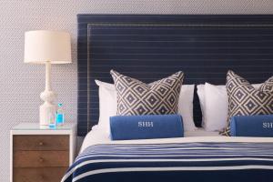 a bedroom with a blue and white bed with pillows at Harbour Hotel & Spa St Ives in St Ives