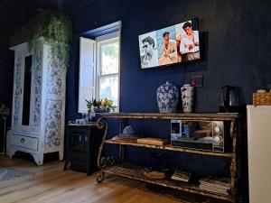 a blue room with a shelf with vases and a picture on the wall at Olive grove cottage in Koringberg