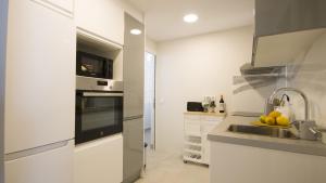 Una cocina blanca con fregadero y microondas. en Apartamento lliteras ref 9003, en Cala Millor 10 fotos más