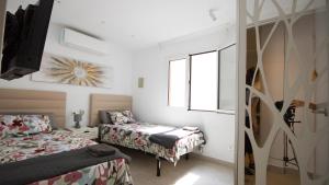 1 dormitorio con 2 camas, TV y ventanas en Apartamento lliteras ref 9003, en Cala Millor