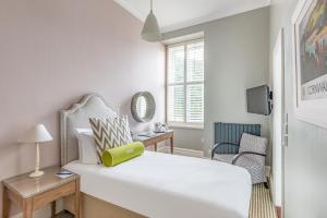 a white bedroom with a white bed and a chair at Harbour Hotel & Spa St Ives in St Ives