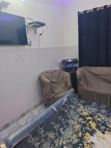 a room with two beds and a tv and a rug at HEAVEN House in Dargai