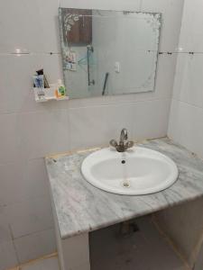 a white sink in a bathroom with a mirror at HEAVEN House in Dargai