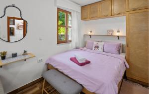 a small bedroom with a pink bed and a chair at Gorgeous Home In Rovinj With Wifi in Rovinj
