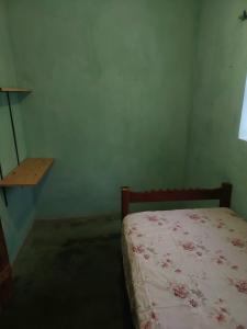 - une chambre avec un lit, une fenêtre et une étagère dans l'établissement Casa na Vila, à Vale do Capão