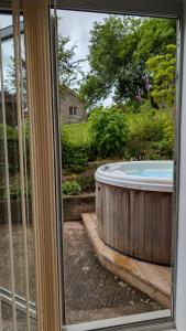 a jacuzzi tub sitting outside of a window at The Snug at Cefn Tilla Court in Usk