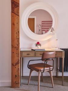 a desk with a chair and a mirror at Harbour Hotel & Spa St Ives in St Ives