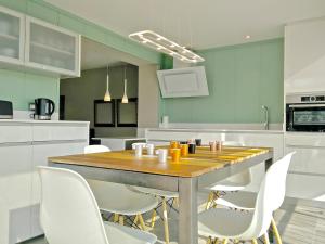 - une cuisine avec une table en bois et des chaises blanches dans l'établissement Ferran Pedralbes Penthouse, à Barcelone