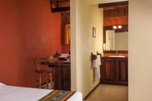 a kitchen with a sink, stove, and refrigerator at Hotel Arenal Lodge in Fortuna
