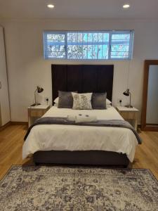 Un dormitorio con una cama grande con dos mesitas de noche. en The Ridge, en Ciudad del Cabo 14 fotos más