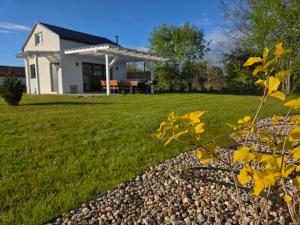 a backyard with a house and a gravel yard at Domek Maryja z prywatnym duzym jacuzzi i sauna Przystan pod niebem in Leczyce