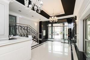 korytarz z czarno-białymi ścianami i żyrandolem w obiekcie Apartments Tartaczna 2 - Gdansk Old Town by Noclegi Renters w Gdańsku