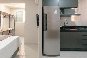 a stainless steel refrigerator in a kitchen at Apartamento Confortável - MEL402 in Maringá +18 photos