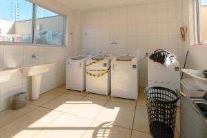 a bathroom with three washing machines and a sink at Apartamento Confortável - MEL402 in Maringá