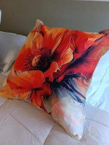 ein Kissen mit einer Blume auf dem Bett in der Unterkunft Aveiro Ria View in Aveiro