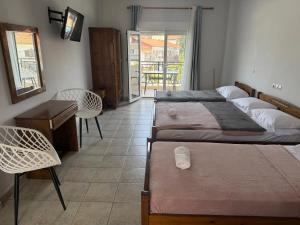 a bedroom with two beds and a table and chairs at Kalithea Central View Apartments in Kallithea Halkidikis