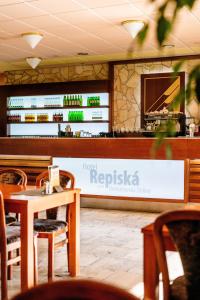 a restaurant with a counter and a table and chairs at Wellness Hotel Repiska in Belá
