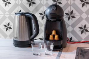 - une cafetière noire et deux verres sur une table dans l'établissement Nice Renting - VERDUN - Designer Cocoon Massena Calm Air Conditioning, à Nice