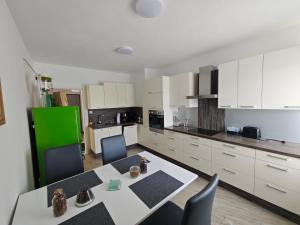 a kitchen with white cabinets and a table and chairs at Großzügige Wohnung mit Terrasse in Zeltweg