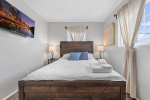 1 dormitorio con 1 cama con sábanas blancas y almohadas azules en Charming Gem in LH, High Speed WiFi Minutes from Beach, Downtown & Petco Park!, en San Diego