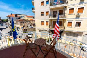 two chairs sitting on a balcony with an american flag at Gjuhadoli Hotel 2 in Shkodër