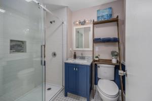 a bathroom with a toilet and a glass shower at Bluestar Cottage - Hot Tub Pergola and Fire pit in Saugatuck