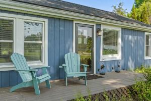 two chairs sitting on a deck next to a house at Bluestar Cottage - Hot Tub Pergola and Fire pit in Saugatuck