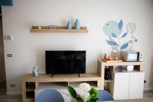 a living room with a tv and a table at Il Confine Azzurro in Porto SantʼElpidio