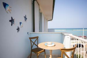 a small table and chairs on a balcony with the ocean at Il Confine Azzurro in Porto SantʼElpidio